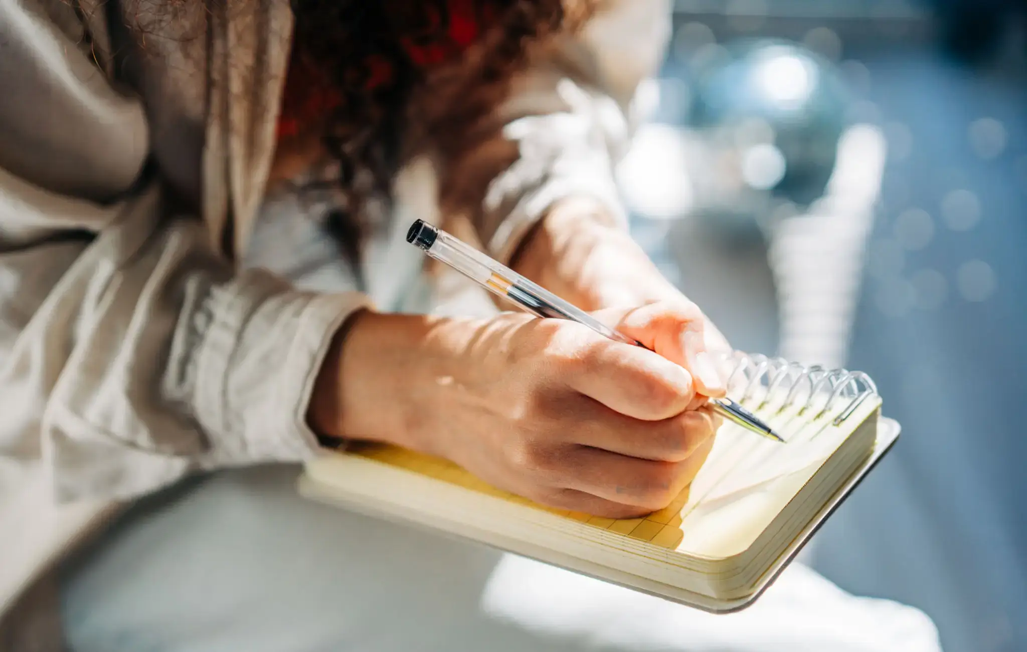 Someone writing on a notepad with a biro